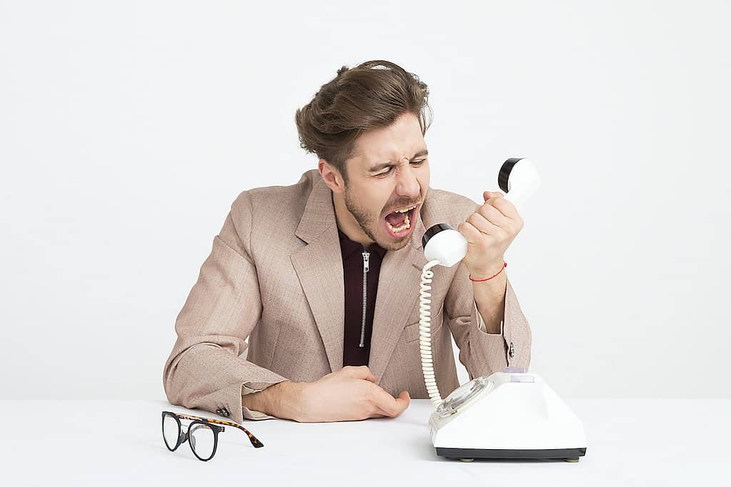 An angry male customer shouting into a telephone.