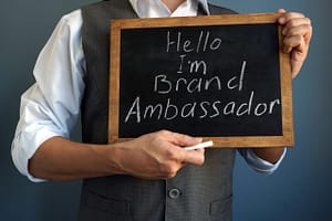 Picture of a man holding a small chalkboard with the words, “Hello, I’m Brand Ambassador.”